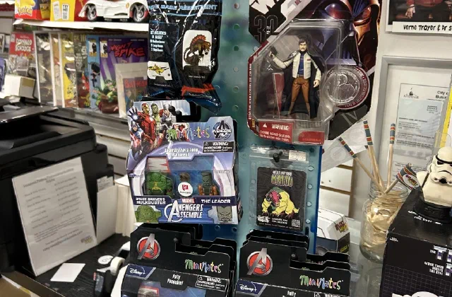 A spinner rack of carded action figures beside a counter